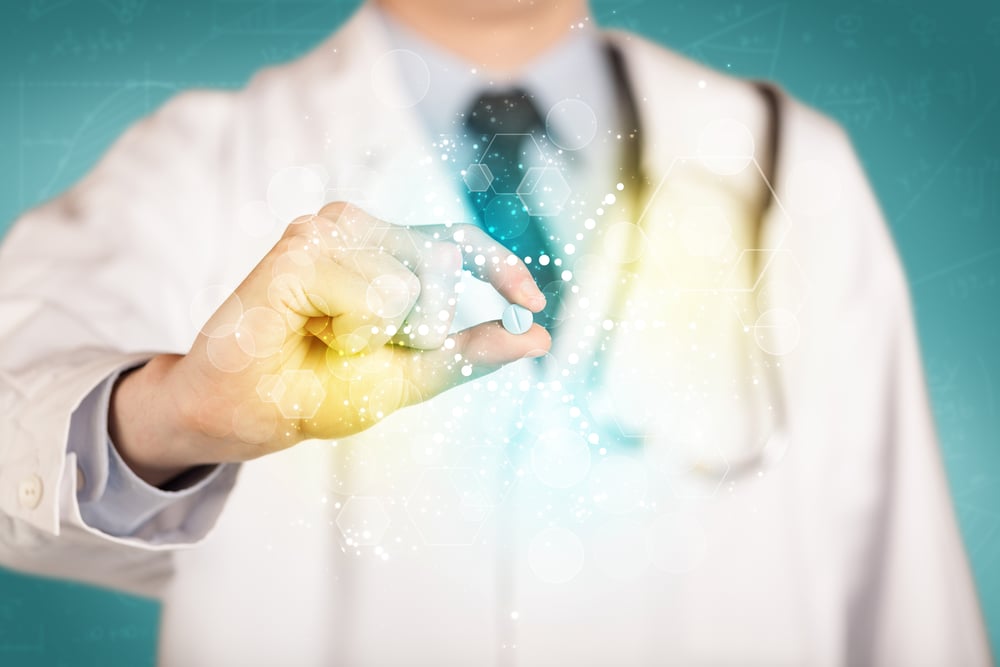A male doctor in white coat with a stethoscope holding a pill with glowing colorful dots and lines A male doctor in white coat with a stethoscope holding a pill with glowing colorful dots and lines